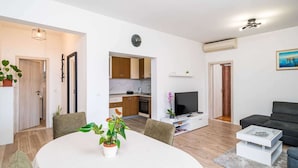 Un apartamento moderno con comedor, cocina, sala de estar y un balcón.
