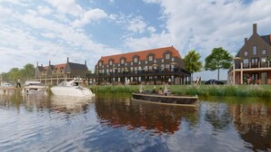 A riverside hotel with a traditional architectural style, featuring multiple buildings with gabled roofs and a dock with boats. - Loft Apartment by Veerse Meer Marina (Kamperland)