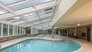 An indoor swimming pool with a glass ceiling, stone flooring, and a clear view of the outside. - Ultimate ski-in, ski-out!  Steps from ski lifts & gondola. Resort amenities! Air Conditioning! (Breckenridge)