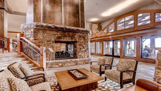 A spacious lobby with a stone fireplace, leather sofas, and a staircase leading to upper floors. - Ultimate ski-in, ski-out!  Steps from ski lifts & gondola. Resort amenities! Air Conditioning! (Breckenridge)