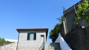 Un edificio in pietra con una piccola finestra e una scala che vi conduce.
