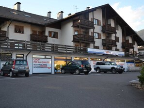 Un edificio de varios pisos con un estacionamiento al frente.
