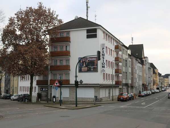 Stylish building with a pension advertisement on its facade, featuring multiple windows and balconies.