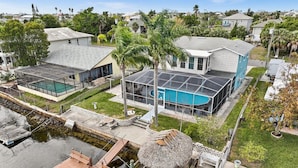 A residential property with a swimming pool, a dock, and a thatched-roof structure. - HEATED POOL screened in - PET - TIKI - 4 Kayaks - Private Fishing & Boating Dock (Hernando Beach)