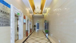 A hotel corridor with a tiled floor, a chandelier, and directional signs on the walls. - Vienna Classic Hotel (Shanghai Tinglin) (Shanghai)