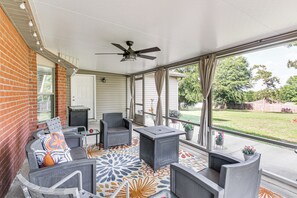A covered patio with a ceiling fan, grey outdoor furniture, and a patterned floor. - Crestview Family Home: Screened Porch & Games! (Crestview)