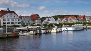 A waterfront area with buildings, boats, and a dock. - Apartment in Lubeck-travemunde (Lübeck)