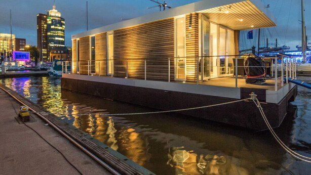 A modern waterfront building with a flat roof, large windows, and a covered outdoor area. - Apartment in Lubeck-travemunde (Lübeck)