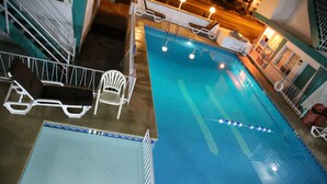A swimming pool with lounge chairs and a lifeguard stand. - El Ray motel (Wildwood)
