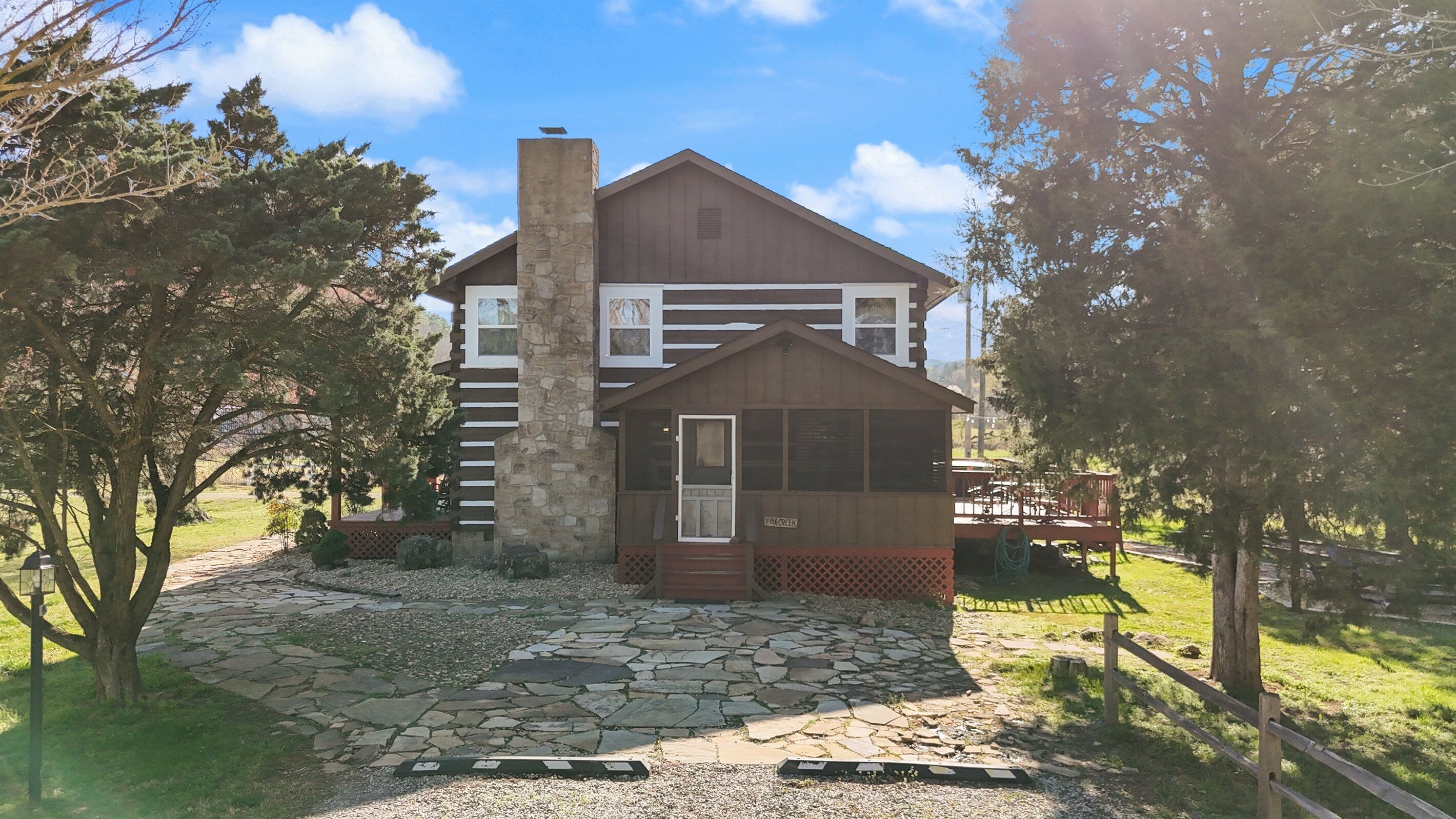A two-story building with a stone facade, a small porch, and a stone pathway leading to the entrance.