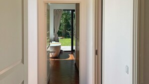 A hallway leading to a bathroom with a bathtub and a shower area. - 10 Person Holiday Home in Vejby (Vejby)