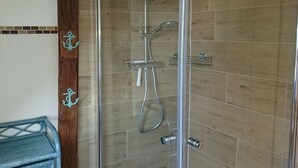 A glass-enclosed shower with a wooden wall and tiled floor. - Holiday Apartment Red Milan (Bobitz)