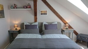 A bedroom with a bed, two nightstands, a bench, a shelf with decorative items, and a picture on the wall. - Holiday Apartment Red Milan (Bobitz)