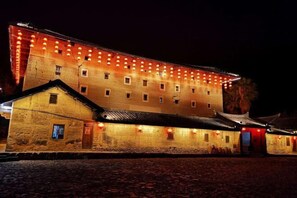 A historic building with a stone facade, multiple windows, and a traditional roof. - Nanjing Sister Inn (Nanjing County)