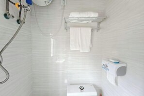 Ein kleines, weißes Badezimmer mit Dusche, Toilette und Handtuchhalter.