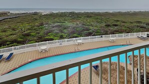 A pool area with a view of the ocean and a beach. - Grand Caribbean by Silver Sands Vacation Rentals (Port Aransas)