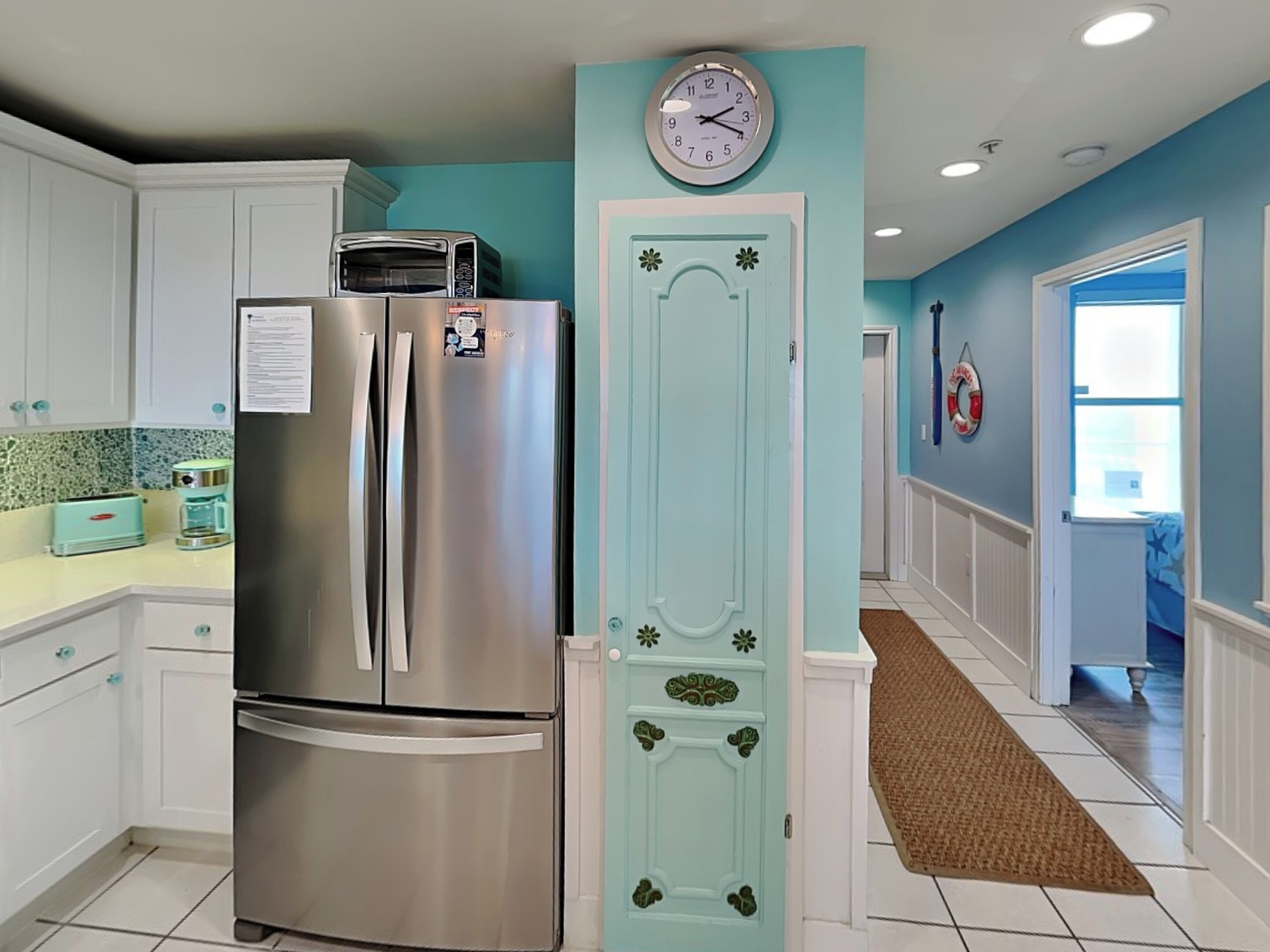 A kitchen with a stainless steel refrigerator, a toaster, and a coffee maker on the counter.