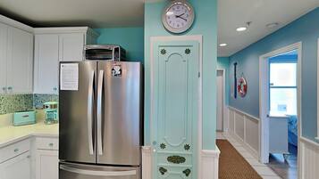 A kitchen with a stainless steel refrigerator, a toaster, and a coffee maker on the counter.