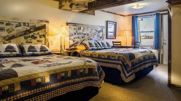 A cozy bedroom with two beds, a desk, and a chair. - Relax by the lake in Room 10 - The Antique Room - Curriers Lakeview (Rice Lake)