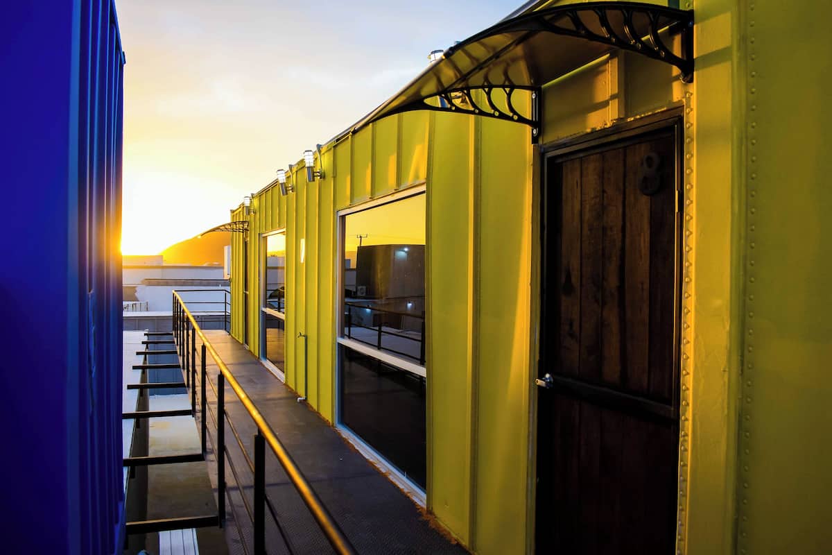 A corridor with yellow walls, a wooden door, and a window.