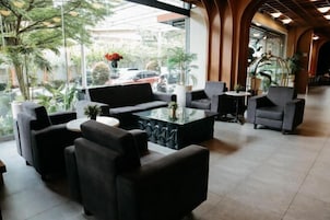 Un vestíbulo moderno con un sofá, sillones y una mesa de centro.