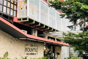 Un hotel llamado 'The Buntie' con un diseño arquitectónico moderno, que destaca una escalera prominente y un fachada de vidrio.