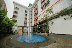 Un patio con una piscina circular, rodeado por edificios de varios pisos con balcones.
