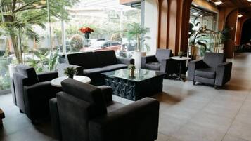 A lobby with a sofa set, a coffee table, and a view of the street.