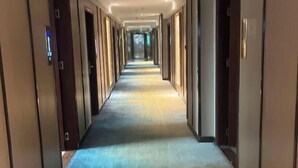 A long, narrow hotel corridor with doors on both sides and a carpeted floor. - Yunjing hotel (Dongguan)