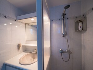 Ein modernes Badezimmer mit Waschbecken, Spiegel und Dusche.