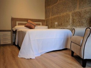 A neatly arranged bedroom with a bed, a chair, and a nightstand. - Belvilla by OYO Villa Trabazos Abellas (Ourense)