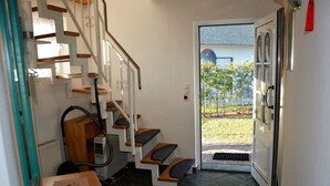 A staircase leading to a door with a view of a garden. - Holiday House House by the Lake (Krakow am See)
