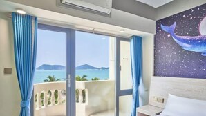 A hotel room with a bed, a nightstand, a window with curtains, and a painting of a whale. - Xiachuan Island Haijiao Hotel (Taishan)