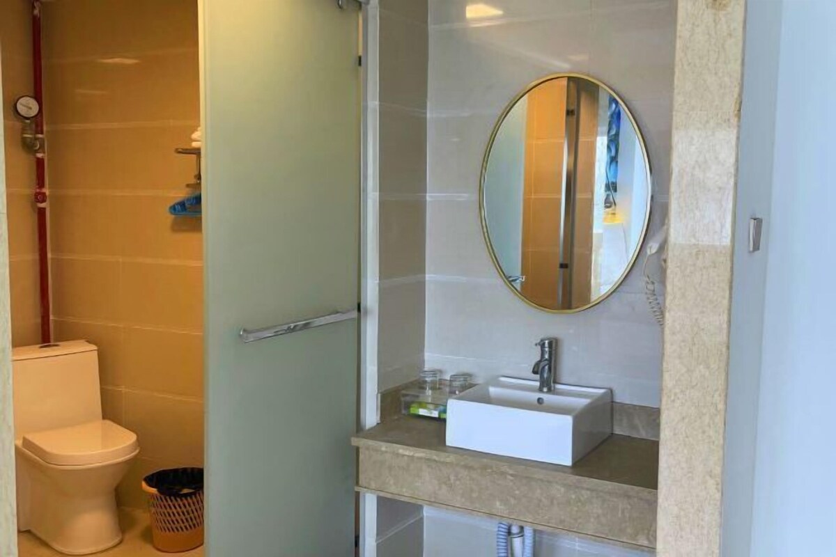 Un baño con inodoro, lavamanos, espejo y ducha.
