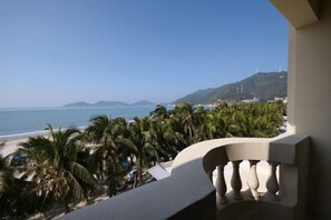 Un balcón con vista a una playa y palmeras.