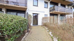 Un immeuble d’appartements moderne avec un chemin en briques menant à l’entrée.