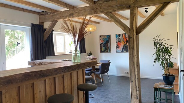 A rustic interior with exposed wooden beams, a bar area with stools, and a dining space with chairs. - Spacious Holiday Home in the Teutoburg Forest (Schieder-Schwalenberg)