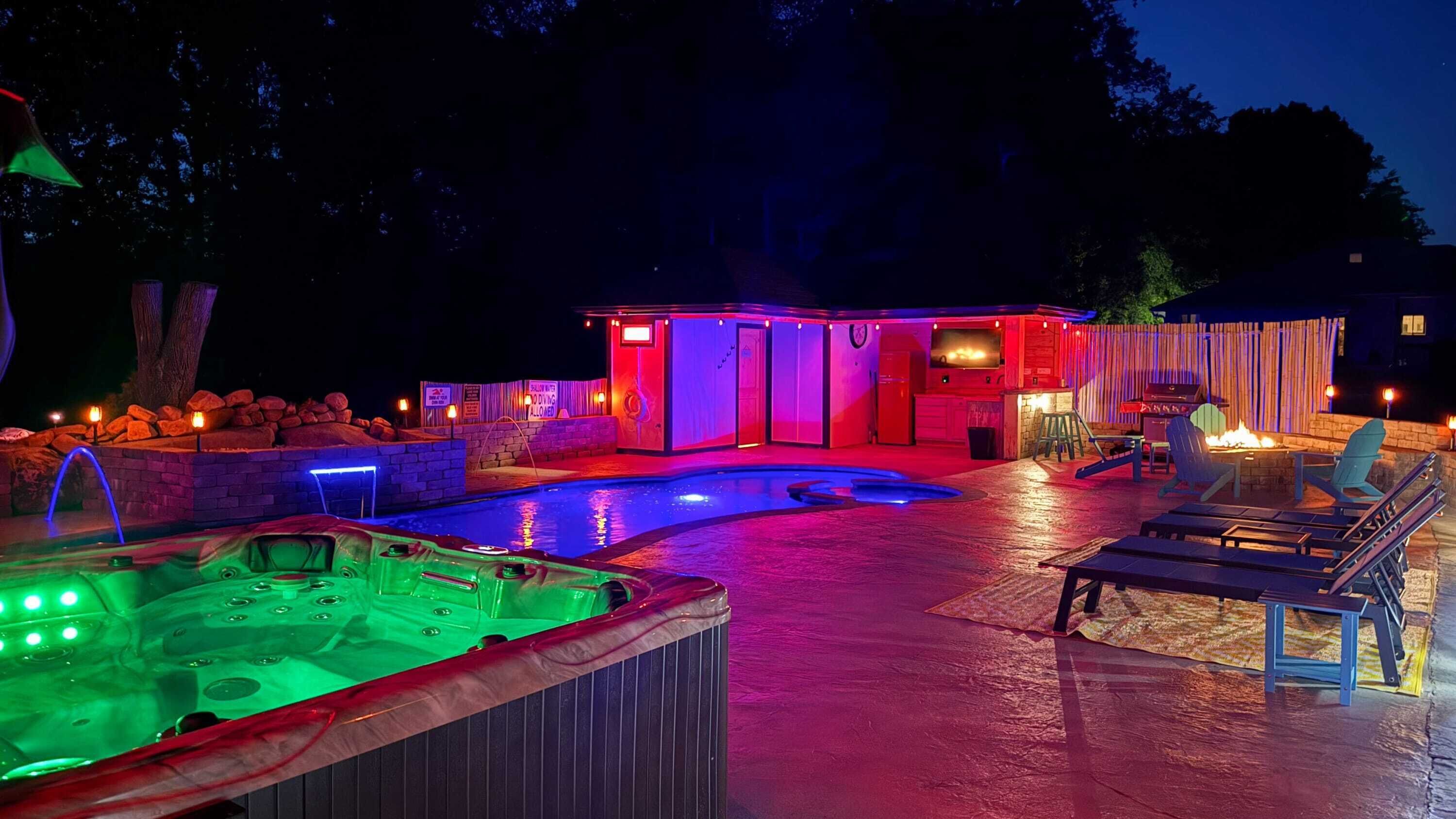 Un área de piscina con jacuzzi y zona de barbacoa.