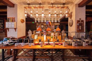 A hotel lobby with a long reception table, multiple pendant lights, and a variety of items on display. - Shunhe Tianxi Hotel (Jinan Station, Jinan Maternal & Child Health Hospital) (Jinan)