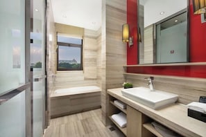 A modern bathroom with a bathtub, a sink, and a large mirror.