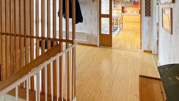 A wooden staircase leading to a room with a view of a dining area.
