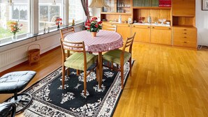 A dining area with a round table, chairs, a rug, and a view of the outdoors. - 4 Person Holiday Home in Solvesborg (Sölvesborg)