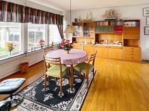 A dining area with a round table, chairs, a rug, and a view of the outside. - 4 Person Holiday Home in Solvesborg (Sölvesborg)
