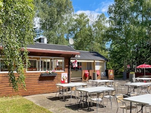 Puurakennus, jossa on patio, ulkotila istumiseen ja satelliittiantenni.