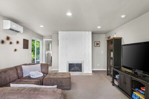 Smart-tv, een open haard, boeken en een computerscherm