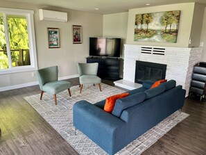 Smart TV, chimenea, libros y monitor de computadora 