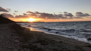 A beach at sunset with waves gently lapping the shore. - Villa Bi de Kuhlung Comfortable Vacation Home (Rerik)