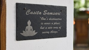 Een plaquette met een citaat van Casita Samsari op een witte muur.