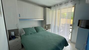 Une chambre à coucher avec un lit, une armoire, un bureau et une télévision.