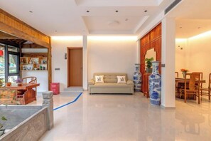 Un interior moderno con un sofá, una mesa de comedor y jarrones decorativos.